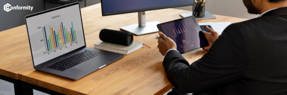 Profissional de qualidade analisando gráficos de desempenho em tablet e notebook para estruturar uma ação corretiva no Conformity.